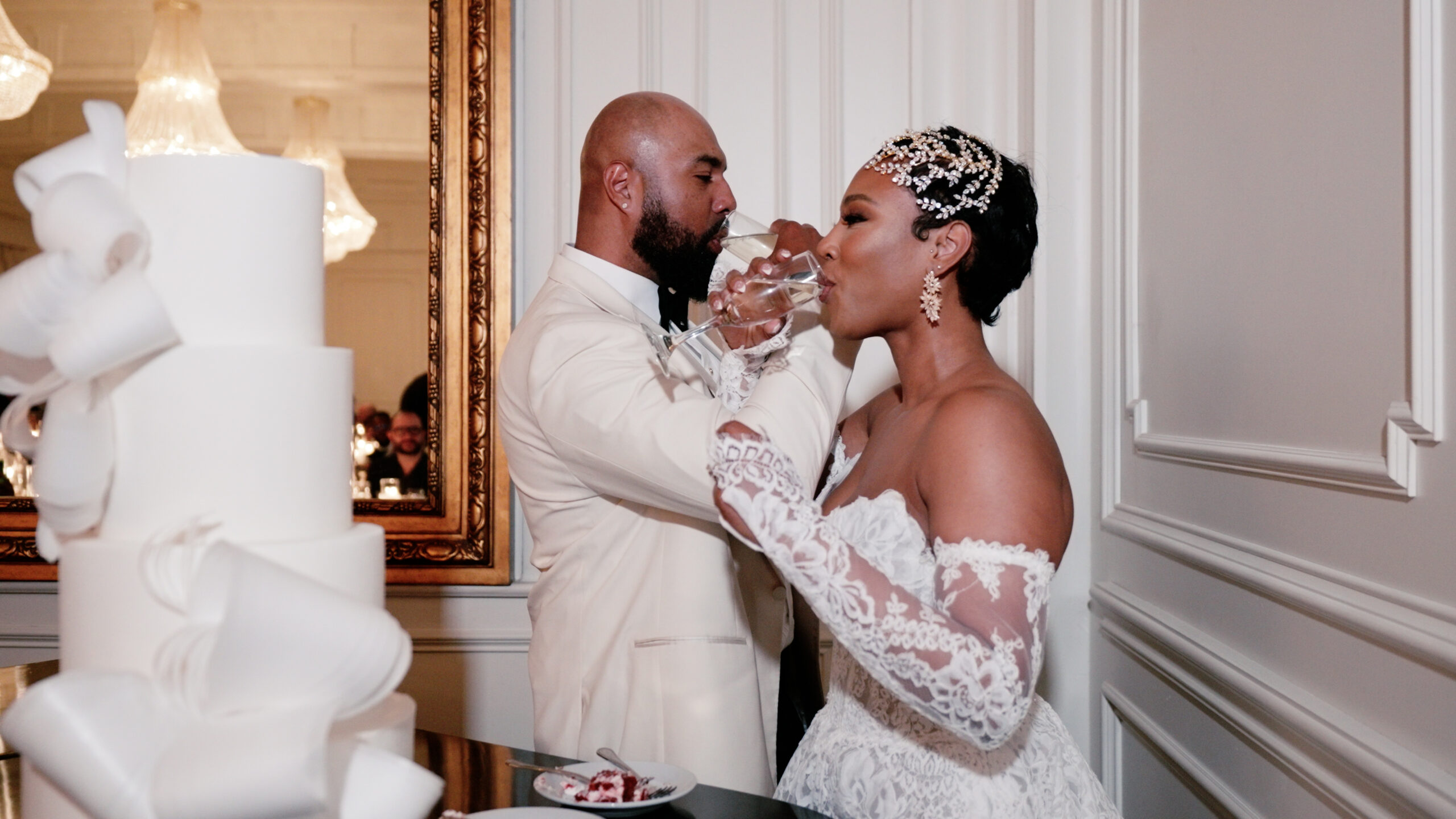 Bride and groom cross arms to drink their champagne as they smile in this joyful moment at their wedding in Dallas, TX.