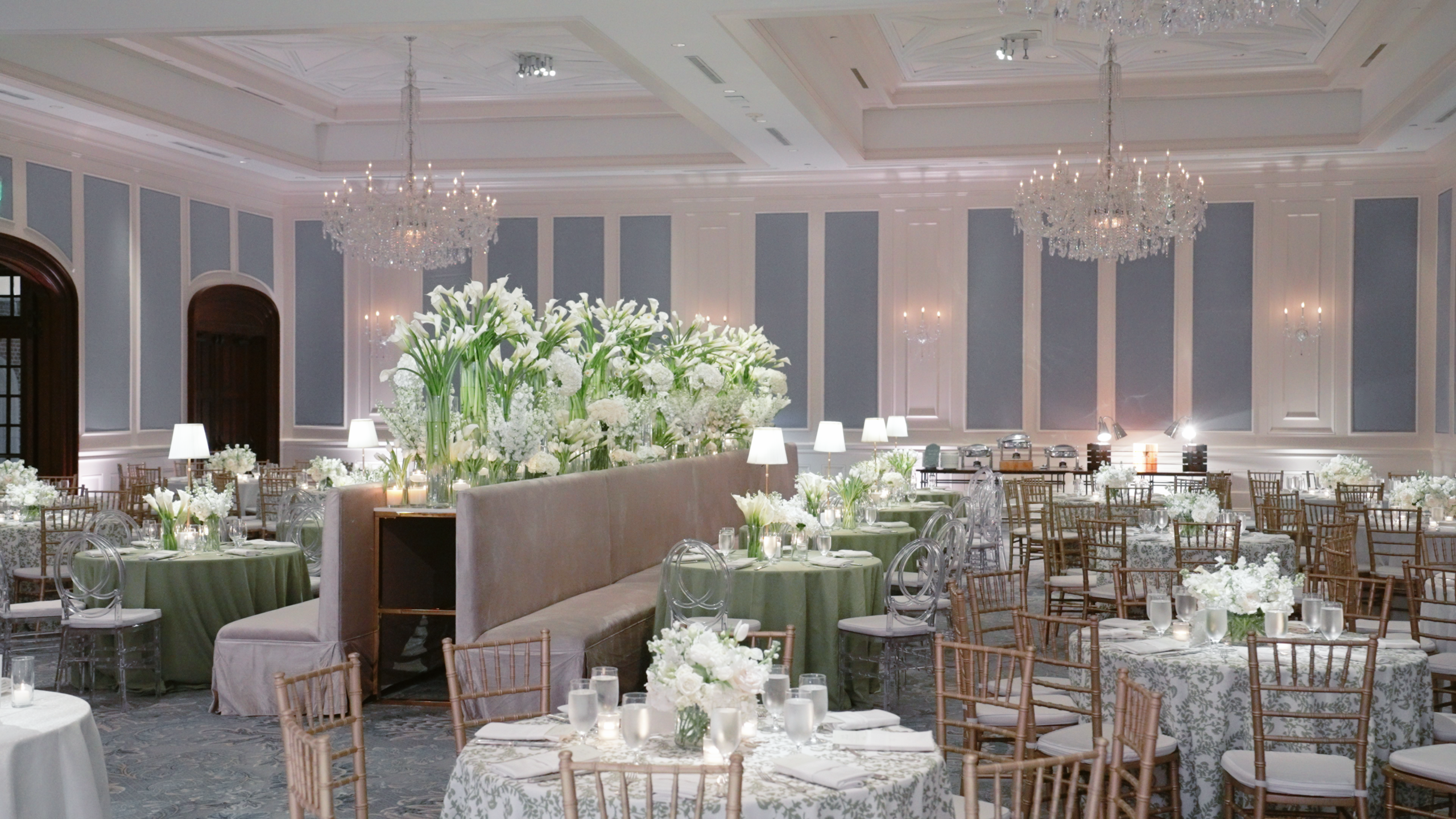 Hotel wedding set up in Dallas with large white flowers and blue paneling.