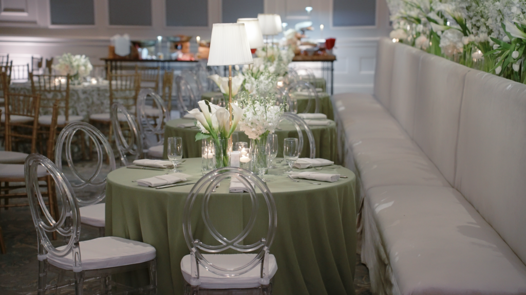 Tables set up next to a large bench with chairs around it at a wedding in Boston, MA.
