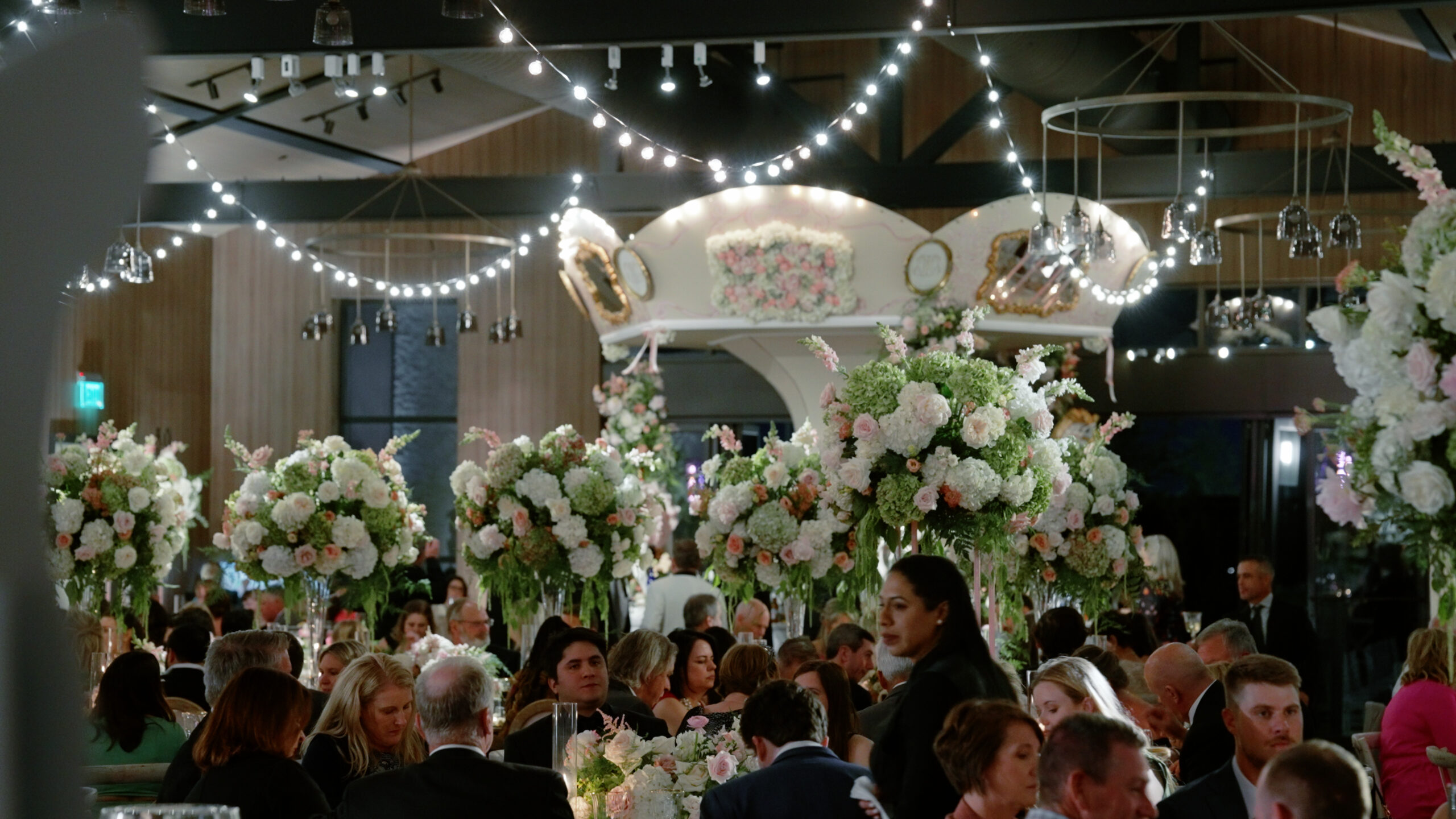 Massachusetts wedding venue featuring an indoor carousel, lush floral arrangements, and guests celebrating.