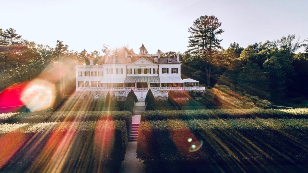 Exterior of The Mount, Edith Wharton’s historic estate in Lenox Massachusetts, with manicured gardens and grand architecture.