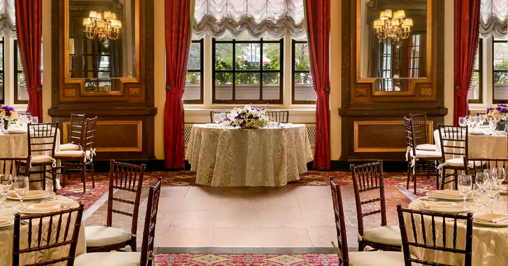 Upscale Boston wedding reception at the Fairmont Boston with elegant place settings and ambient lighting.