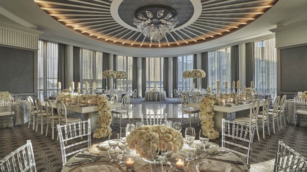 Elegant wedding reception setup at Four Seasons One Dalton Boston with candlelit tables and modern décor.