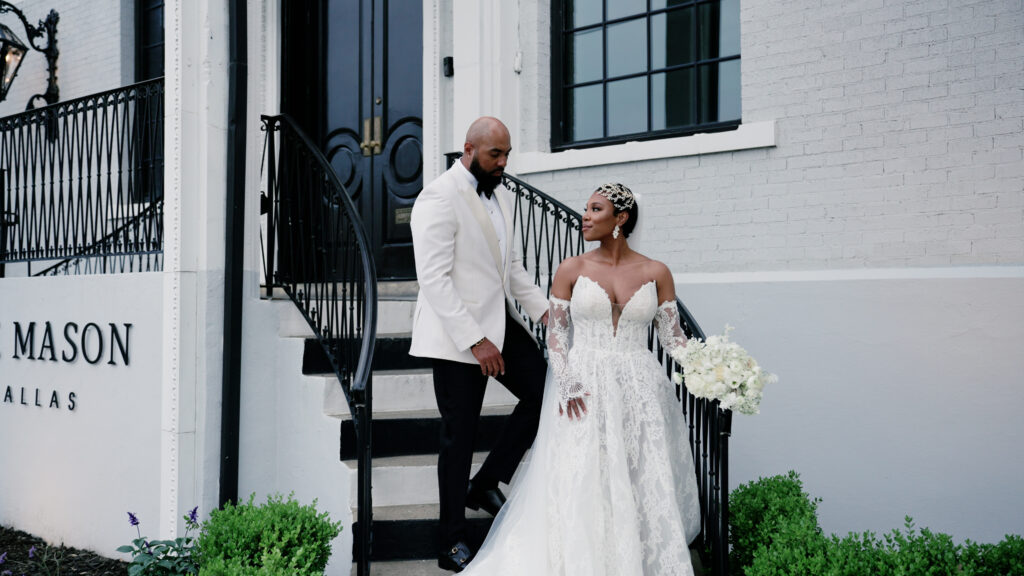 Couple posing for a wedding photo in front of The Mason in Dallas, Texas, showcasing a romantic moment against the venue’s historic brick exterior and urban industrial backdrop.