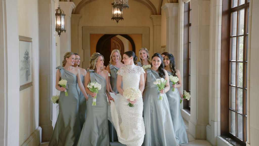 Bride and bridesmaids walking through a hotel hallway while preparing for the ceremony, captured in a candid pre-wedding moment.