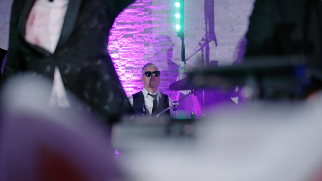 Drummer performing live at a wedding reception, capturing an energetic moment during the celebration as guests dance and enjoy the lively music.
