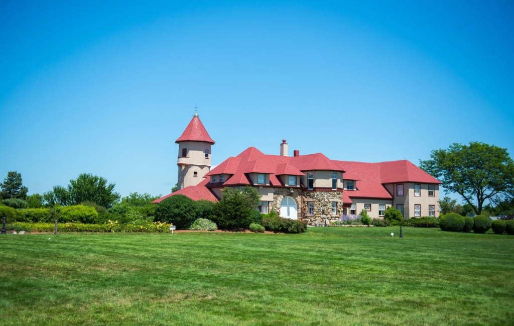 Exterior of Ocean Edge Resort & Golf Club set up for a wedding, featuring a coastal New England estate with manicured lawns, elegant tented reception space, and scenic waterfront surroundings.