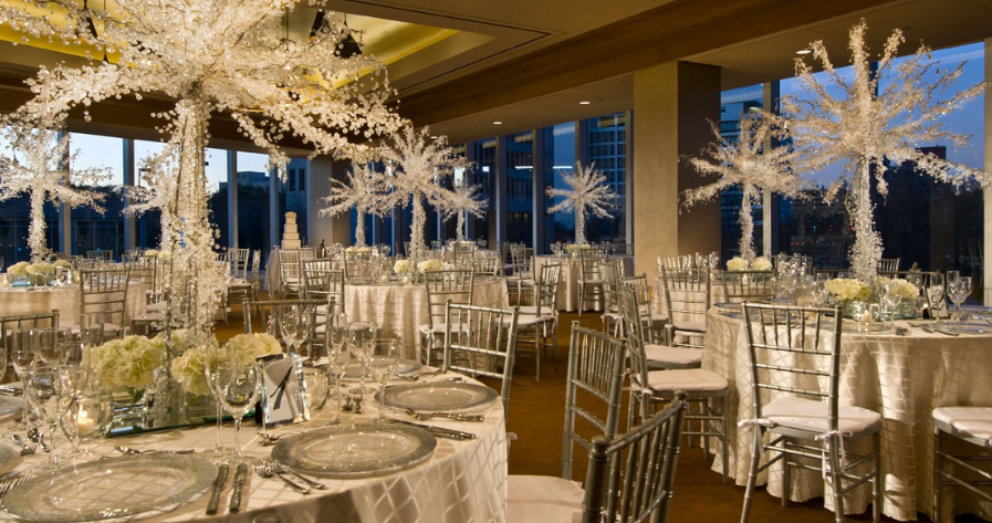 Wedding celebration at Omni Dallas Hotel featuring a vibrant reception atmosphere, elegant décor, and chairs prepared for guests to celebrate in a modern ballroom setting.